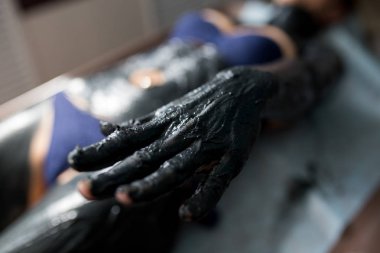 Genç kadın salonda Spa tedavi görüyor. Kil vücut maskesi uygulamak sahip güzel bir kız. Çamur terapisi. El yakın çekim