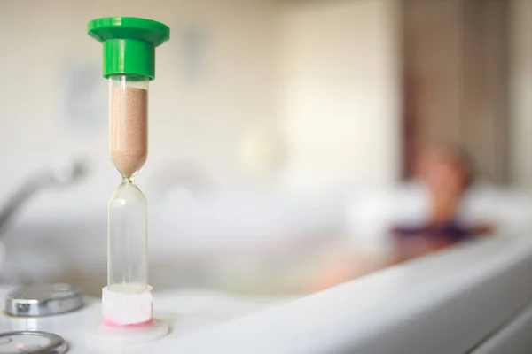 Foreground Hourglass Background Woman Relaxing Bathtub Sandglass Female Patient Receives — Stock Photo, Image