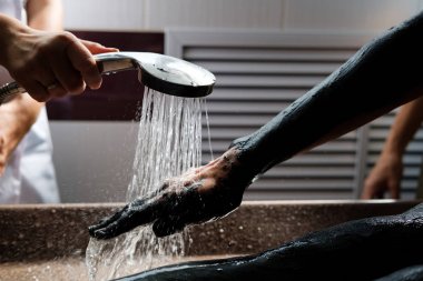 Kil vücut maskesi Bayan hasta üzerinde kapalı yıkama güzellik uzmanı. Spa muamele salonda kadın. Çamur terapisi, hidroterapi. Elinde yakın çekim