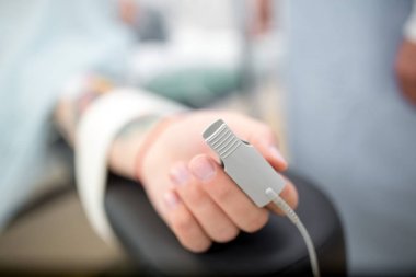 Nabız oksimetre ameliyat sırasında hastanın parmağına. erkek hasta hastane yatakta yatıyordu. Tıp, cerrahi, canlandırma, acil durum kavramı. Yakın çekim