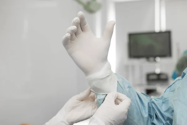 外科医生正在准备手术 助手帮助经验丰富的首席外科医生戴上无菌橡胶手套 急救概念 — 图库照片