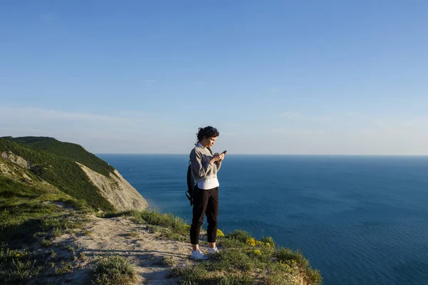 Piękna Brunetka Kobieta Wzgórzu Nad Morze Pomocą Smartfona — Zdjęcie stockowe