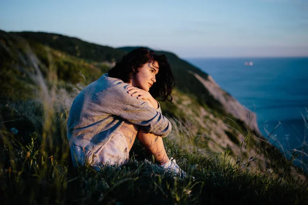 Красивая Брюнетка Женщина Сидящая Траве Холмы Море Девушка Расслабляющий Открытый — стоковое фото