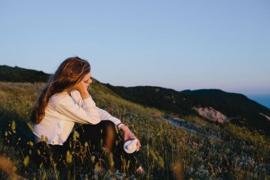 şişe su tepe üzerinde rahatlatıcı olan genç spor kadın. Kız genç doğa üzerinde manzarayı içecek ile. Fitness, sağlıklı yaşam, spor, sakin ol ve sağlık kavramı. Kopya alanı