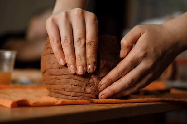 Woman's hand making clay pot on the pottery workplace. Ceramist modeling on pottery workshop. Close up