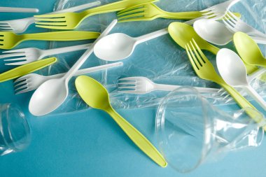 Tek kullanımlık kaşıklar, çatallar ve bardaklar, tek kullanımlık sofra takımı, plastik kirlilik, atık, ekoloji, ekoloji, geri dönüşüm. Plastik işleme sorunu