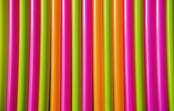 Colorful plastic Drink straws on blue background. Equipment for single use. Plastic pollution, waste, eco, ecology, recycle. Plastic processing problem. Close up. Flat lay