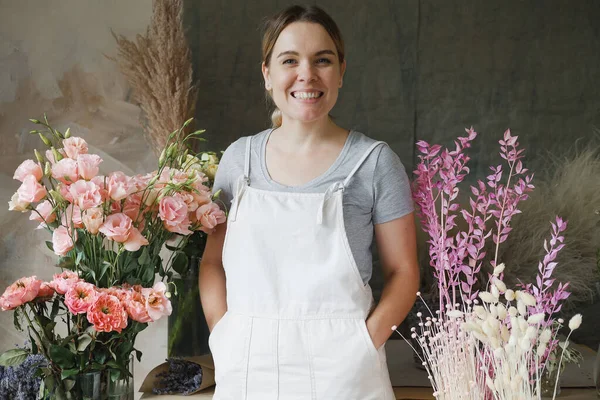 woman in apron standing on flower background. Entrepreneurship, florist, craftsman, artisan, craft, service, cook,  small business, workplace concept
