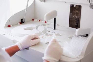 Laboratuvarda araştırma yapan bir araştırmacı. Laboratuvarda biyolojik test yapan bir bilim adamı. Doktor makinede tıbbi analiz yapıyor. Coronavirus COVID-19, aşı üretimi. Kapat.