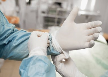 Coronavirus COVID 19 korunması için doktorun eline steril lastik eldiven takmış hemşire. Salgın virüs salgını kavramı