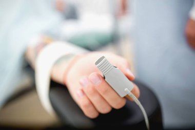 Nabız oksimetresi hastanın parmağında. Hastanedeki yoğun bakım odasında erkek hasta ve tıbbi malzemeler. Yoğun bakım ünitesi, yoğun terapi, yoğun tedavi.. 