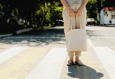 Sokakta yürüyen beyaz elbiseli genç bir kadın.