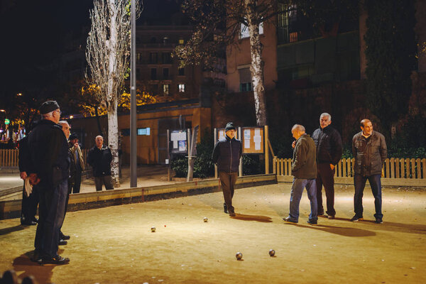 Люди играют в петанке в Барселоне
