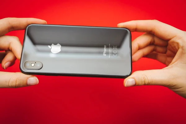 Sosteniendo en las manos un nuevo teléfono inteligente insignia de Apple Iphone X —  Fotos de Stock