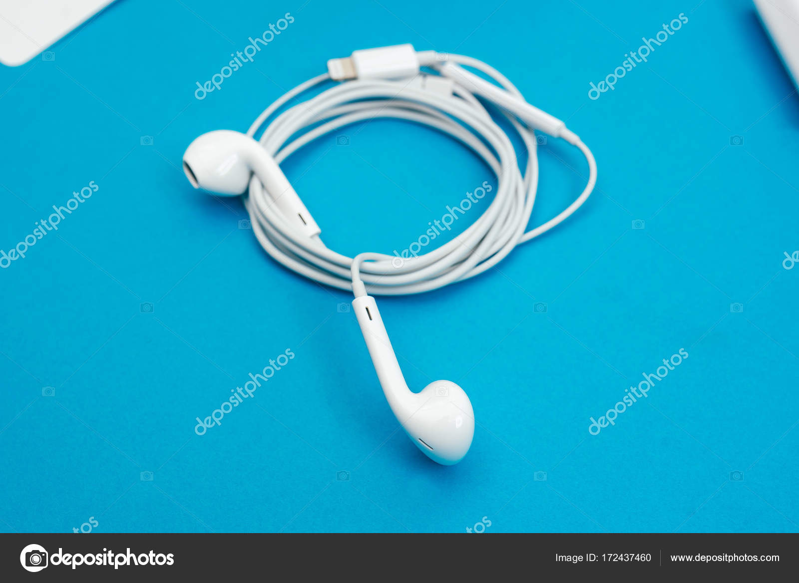 Apple headphones on blue background — Stock Editorial Photo