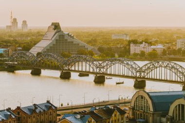 Riga, Letonya - 23 Ağustos 2016: Riga panoramik manzarasını nehir ve Köprüsü'nde yaz günbatımı Zamanı. 