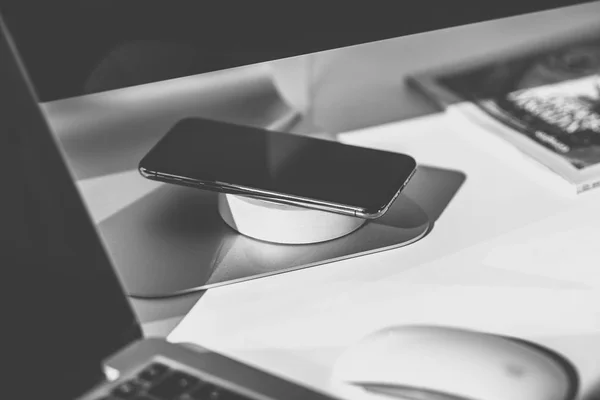 Mobile phone and wireless charger on office table — Stock Photo, Image