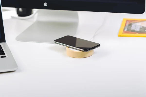 IPhone X smart phone and wireless charger on working table — Stock Photo, Image