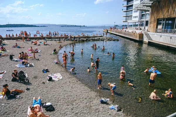 İnsanlar güneşli bir yaz gününde yüzüyor ve güneşleniyor. — Stok fotoğraf