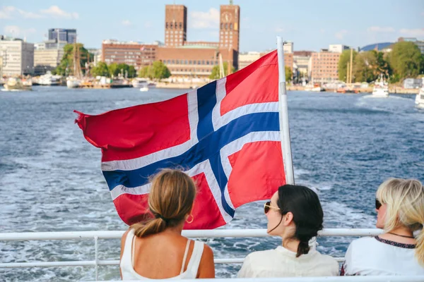 Norwegian flag on a boat with city in background. Oslo, Norway — Stok fotoğraf