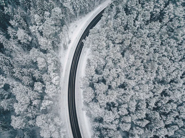 Drone vista aérea de la carretera en el bosque nevado — Foto de Stock