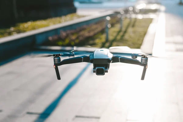 Flying drone with the city in background