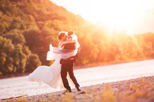 Just Married Couple Spinning on Beach Riverside Background