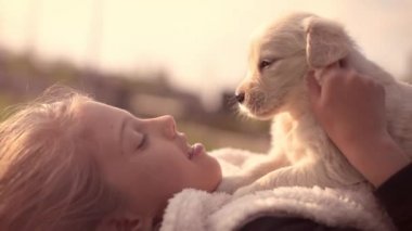 Beyaz Golden Retriever yavru köpek ile sahibi kız açık havada Park'ın bahçesinde döşeme sarılma yaz bahar gün öpüşme sevişme sarılma