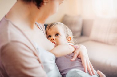 genç anne sevimli küçük kız evde besleme Close-Up