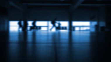 İnsanlar gün batımında havaalanında yürüyorlar. Tanımlanamayan bulanık siluet