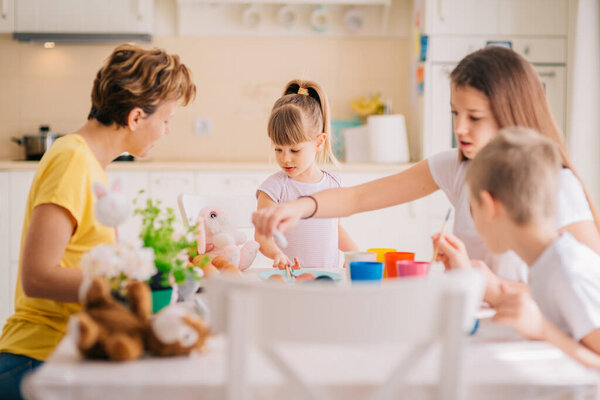 Family Easter Decoration Painting Eggs Mom with three kids