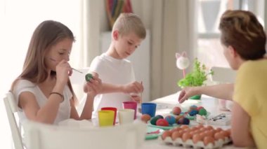 Güzel bir ailenin evde paskalya yumurtası boyadığı görüntüler.