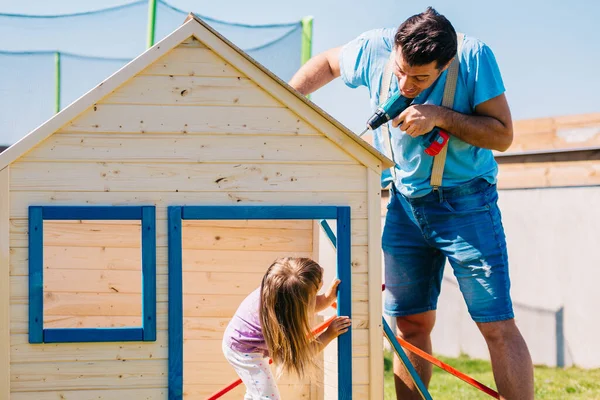 Vader Maakt Houten Huis Voor Zijn Dochtertje Stockafbeelding