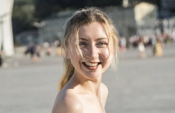 Retrato de una hermosa sonrisa joven rubia en una calle de la ciudad en un día soleado — Foto de Stock