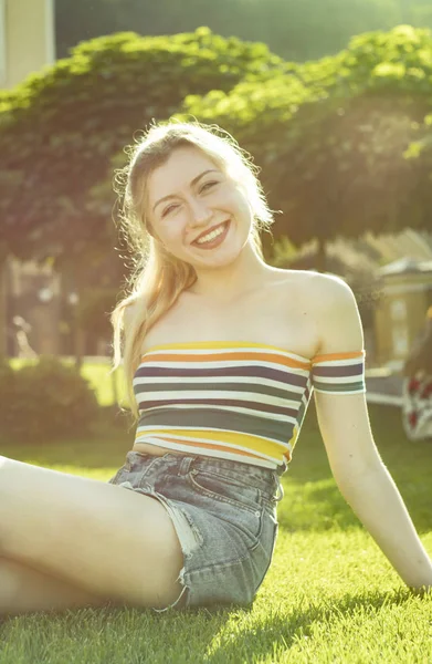 güzel bir genç portresi gülümseme bir şehir parkı, central Park'a kısa bir etek güneşli bir sarışın kız