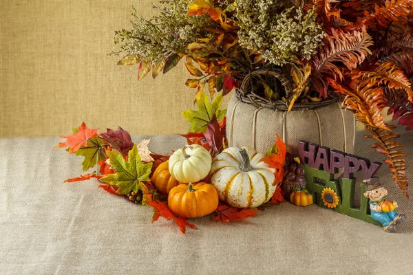 Pumpkins with fall leaves on sackcloth — Stock Photo, Image