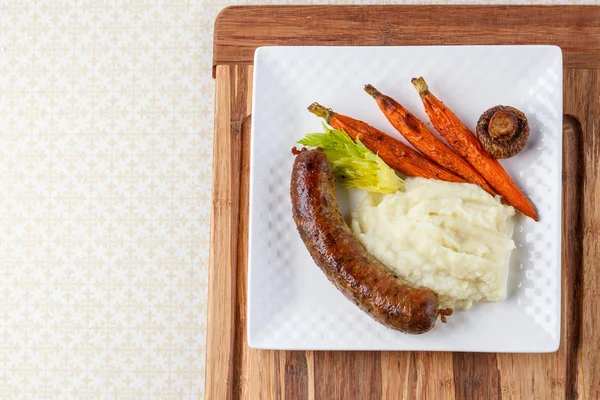 Grilled sausages with mashed potato square plate on wooden background — Stock Photo, Image
