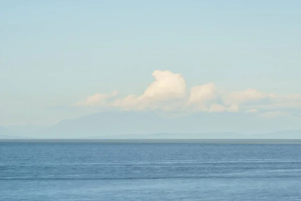 Uitzicht op de oceaan met blauwe lucht en witte wolken — Stockfoto