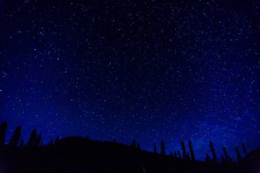 Mavi karanlık gece gökyüzüne bir evren arka plan olarak birçok başlar.