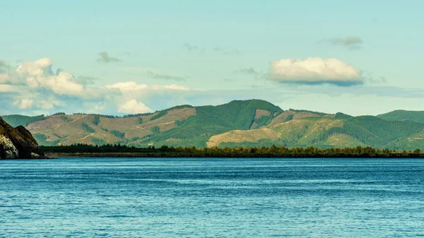 Pasifik Okyanusu sabah bulutlu gökyüzü ve renkli dağ.