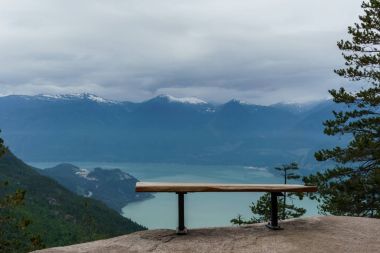 Empty bench on top of a cliff overlooking the Howe Sound. clipart
