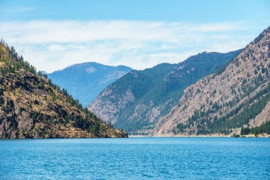 Seton göl kenarında mavi gökyüzü ile Lillooet British Columbia Kanada yüksek dağlar.