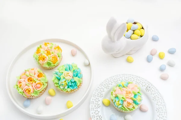 Tema de Páscoa cupcakes decorados em fundo branco com um coelho . — Fotografia de Stock