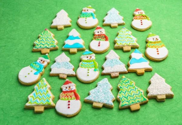 Muñeco de nieve de Navidad y galletas de árbol sobre fondo verde . — Foto de Stock