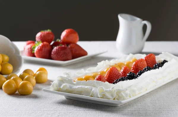 Jahody, golden berry a černé bobule se šlehačkou na talíři jako sladkou svačinu. — Stock fotografie