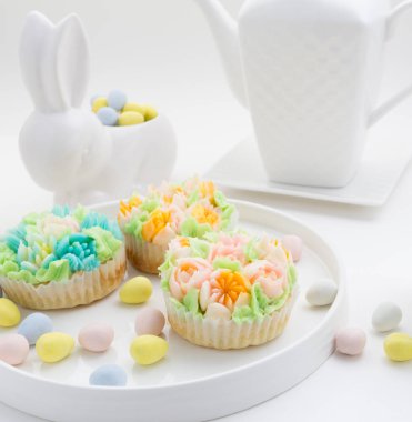 Üstten Görünüm Paskalya yumurta beyaz arka plan üzerinde ile cupcakes dekore edilmiştir..