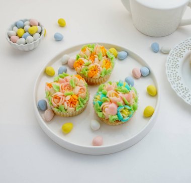 Üstten Görünüm Paskalya yumurta beyaz arka plan üzerinde ile cupcakes dekore edilmiştir..