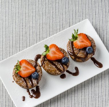 Yaban mersini çilek ahududu ile lezzetli çikolatalı mini cheesecakes.