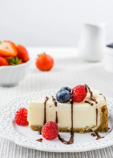 Läcker cheesecake med jordgubbar på ett bord mot vit vägg. — Stockfoto