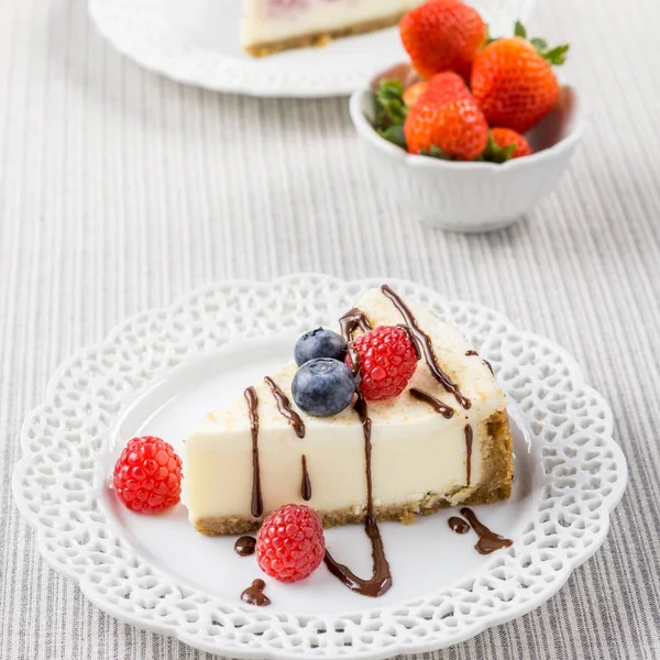 Heerlijke cheesecake met aardbeien en bosbessen in de weergave van een tafelblad. — Stockfoto